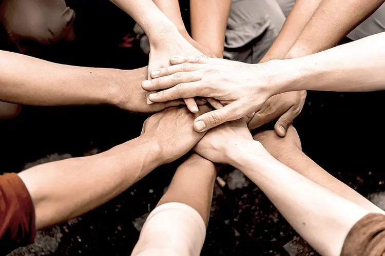 Gruppe von Händen übereinander gelegt